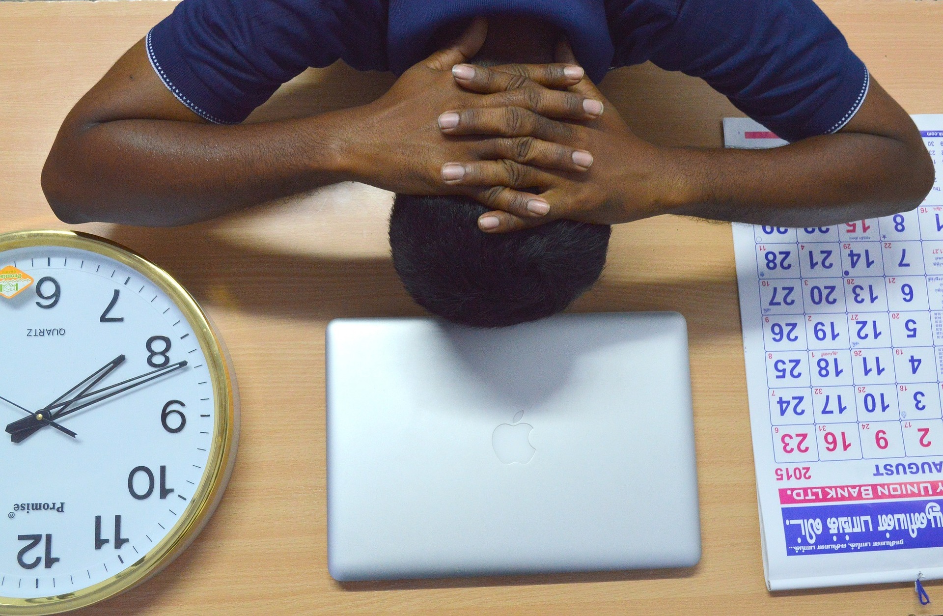 man banging his head against his desk
