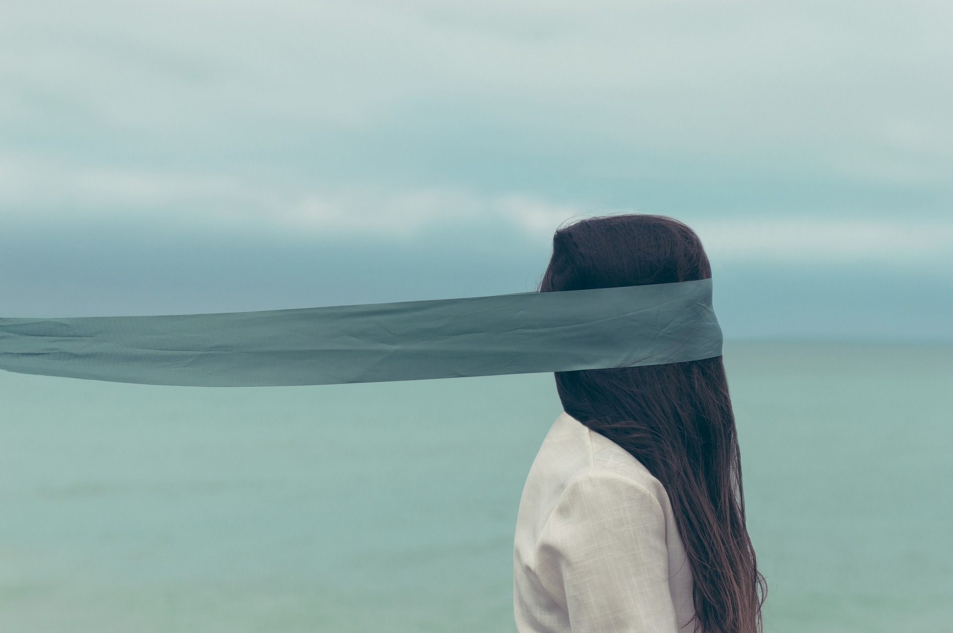woman in a blindfold by the ocean